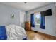 This bedroom has light blue walls and a window with blue curtains. A TV is mounted on the wall at 1927 N Cherry St, Columbus, IN 47201