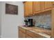 Close up of a coffee maker on a marble countertop, decorative backsplash, and wood cabinets at 1927 N Cherry St, Columbus, IN 47201