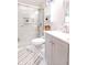 Bathroom featuring walk-in shower with glass doors, white vanity, and grey striped rug at 218 Narcissus Dr, Indianapolis, IN 46227