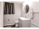 Neutral bathroom featuring a gray vanity with a white sink, rounded mirror and a gray curtain at 218 Narcissus Dr, Indianapolis, IN 46227