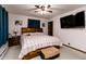 Bedroom with a large bed, ceiling fan, blue curtains and a wall-mounted tv at 218 Narcissus Dr, Indianapolis, IN 46227