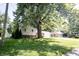 Home featuring a brick facade, siding, driveway, well-maintained lawn, and mature trees at 218 Narcissus Dr, Indianapolis, IN 46227