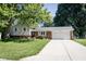 Charming home featuring a brick facade, siding, well-manicured lawn, and an attached two-car garage at 218 Narcissus Dr, Indianapolis, IN 46227
