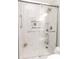 Walk-in shower with frameless glass doors, white marble tiles, built-in niche, and rainfall shower head at 218 Narcissus Dr, Indianapolis, IN 46227