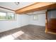 Finished basement with wood trim, wood laminate flooring and two windows at 2606 Shakespeare Dr, Southport, IN 46227