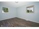Bedroom featuring hardwood flooring and light blue walls, complemented by natural light streaming through two windows at 2606 Shakespeare Dr, Southport, IN 46227