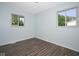 A bedroom with light blue walls, wood floors, and natural light from the windows at 2606 Shakespeare Dr, Southport, IN 46227