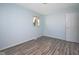 Bedroom with light blue walls, wood-look flooring, and a window at 2606 Shakespeare Dr, Southport, IN 46227