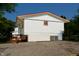 Another side view of this split-level home featuring a pea gravel driveway and a small basement window at 2606 Shakespeare Dr, Southport, IN 46227