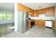 Kitchen with stainless steel refrigerator, wooden cabinets, laminate countertops and vinyl floors at 2606 Shakespeare Dr, Southport, IN 46227