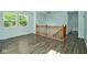 Bright living room with hardwood floors, large windows, and a wooden staircase leading to the second floor at 2606 Shakespeare Dr, Southport, IN 46227