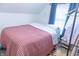 Cozy bedroom featuring a red and white quilt, bright window, and a closet at 2650 S Meridian St, Indianapolis, IN 46225