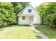 View of white house with well-maintained lawn and lush trees, exuding a tranquil and welcoming atmosphere at 2650 S Meridian St, Indianapolis, IN 46225