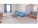 Bright living room featuring neutral carpet, a modern blue sofa, and a dining area in the background at 2650 S Meridian St, Indianapolis, IN 46225