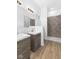 Modern bathroom with double sink vanity, stone tiled shower and wood look flooring at 2709 Station St, Indianapolis, IN 46218