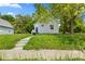 Charming single Gathering home with light siding, overgrown yard, and a concrete walkway at 2709 Station St, Indianapolis, IN 46218