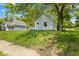 Charming single Gathering home with light siding, overgrown yard, and mature trees at 2709 Station St, Indianapolis, IN 46218