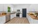 Well-lit kitchen with modern appliances, wood countertops, white cabinets, and durable hardwood floors at 2709 Station St, Indianapolis, IN 46218