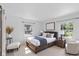 Bright bedroom featuring a Queen size bed, bedside tables and lamps, and a comfortable chair at 2829 Dakota Dr, Anderson, IN 46012