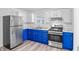 Galley Kitchen featuring stainless steel appliances, crisp white walls, and blue lower cabinets at 2829 Dakota Dr, Anderson, IN 46012