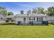 Backyard view of the home featuring a deck, a large yard, and carport at 2829 Dakota Dr, Anderson, IN 46012