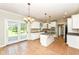 Bright kitchen featuring white cabinetry, center island with cooktop, and glass doors to the backyard at 3050 Montgomery Blvd, Lapel, IN 46051