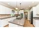 Spacious kitchen with white cabinets, tile backsplash, stainless steel appliances, and center island with cooktop at 3050 Montgomery Blvd, Lapel, IN 46051