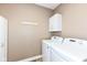 Functional laundry room featuring a washer, dryer, and overhead storage cabinet at 3050 Montgomery Blvd, Lapel, IN 46051