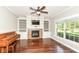 Inviting living room with hardwood floors, fireplace, built-in shelves, and a large window overlooking the yard at 3050 Montgomery Blvd, Lapel, IN 46051