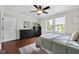 Bright bedroom featuring two windows, modern ceiling fan, and black dresser with dark wood floors at 3101 N Washington Blvd, Indianapolis, IN 46205
