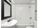A well-lit bathroom features a classic white pedestal sink and subway tile shower at 319 S Webster Ave, Indianapolis, IN 46219