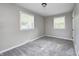 This cozy bedroom features neutral walls, plush carpeting, and large windows for ample natural light at 319 S Webster Ave, Indianapolis, IN 46219