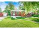 Charming brick bungalow with covered porch, landscaped yard, and sidewalk at 319 S Webster Ave, Indianapolis, IN 46219