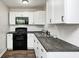 Updated kitchen featuring white cabinets, a modern backsplash, and stainless steel appliances at 319 S Webster Ave, Indianapolis, IN 46219