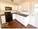 Modern kitchen with white cabinets, black appliances, and dark countertops at 319 S Webster Ave, Indianapolis, IN 46219