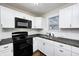 Modern kitchen featuring white cabinets, black appliances, and stainless steel sink at 319 S Webster Ave, Indianapolis, IN 46219