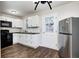 Updated kitchen featuring white cabinets, stainless steel refrigerator, and modern appliances at 319 S Webster Ave, Indianapolis, IN 46219