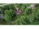 Aerial view of a secluded ranch home surrounded by trees with a large lawn and back deck at 3711 Tara Ct, Carmel, IN 46074