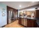 Kitchen featuring stainless steel appliances and an island overlooking the dining area with fireplace at 3711 Tara Ct, Carmel, IN 46074
