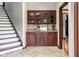 Stylish bar area with wooden cabinets, granite countertop, and convenient access to the staircase at 3893 Bent Tree Ln, Greenwood, IN 46143
