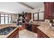 Open-concept kitchen featuring granite countertops, dark wood cabinetry, and stainless steel appliances at 3893 Bent Tree Ln, Greenwood, IN 46143