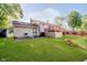 Exterior view of the backyard with a deck, lawn, patio and mature trees, a great space for relaxation and enjoyment at 4020 Eisenhower Dr, Indianapolis, IN 46254