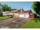View of the home showing the front, driveway, garage and lawn, with a red accent fence at 4020 Eisenhower Dr, Indianapolis, IN 46254