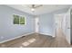 This bedroom features light, airy walls, a ceiling fan, and wood-look flooring at 4305 Five Points Rd, Indianapolis, IN 46239