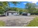 White home with black trim and a detached two-car garage surrounded by mature trees at 4305 Five Points Rd, Indianapolis, IN 46239