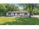 Charming ranch-style home with freshly painted white brick, black trim, and lovely, landscaped yard at 4305 Five Points Rd, Indianapolis, IN 46239