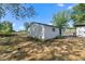 Detached garage with white siding, black trim, and adjacent natural area at 4305 Five Points Rd, Indianapolis, IN 46239