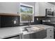 Modern kitchen sink with fixtures set against a sleek backsplash and bright window view at 4305 Five Points Rd, Indianapolis, IN 46239