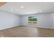 Well-lit living room features wood-look floors and a large window, creating an inviting atmosphere at 4305 Five Points Rd, Indianapolis, IN 46239