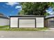 Garage with white siding, black trim, and a white garage door on a paved driveway at 44 S Tremont St, Indianapolis, IN 46222